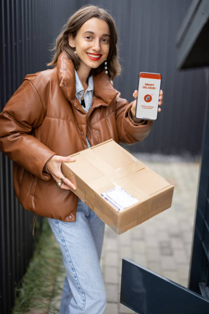 istock Girl with parcel and phone with smart delivery app 1350579775