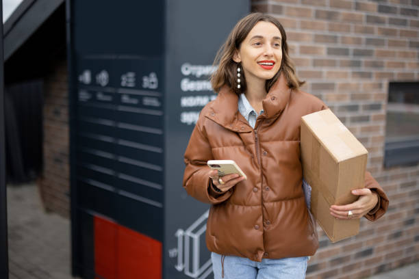 istock Caucasian woman with parcel near post terminal 1350579864