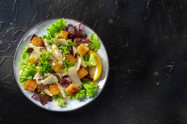 istock Chicken Caesar salad, overhead shot on a black background 1350580791