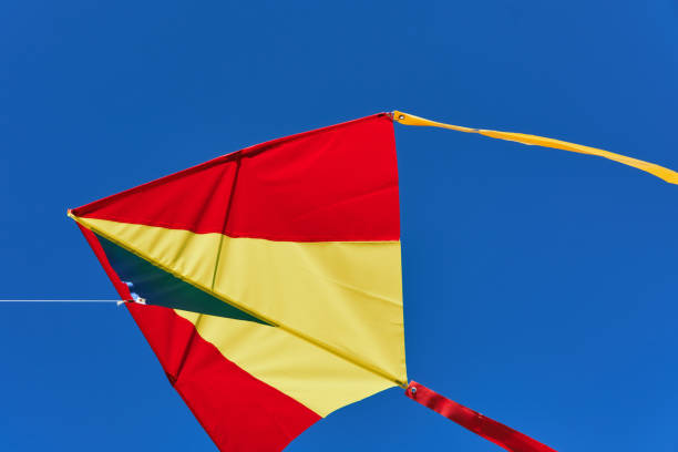 istock Red yellow kite fly high in blue cloudless sky. Soft focus, close-up 1350581859