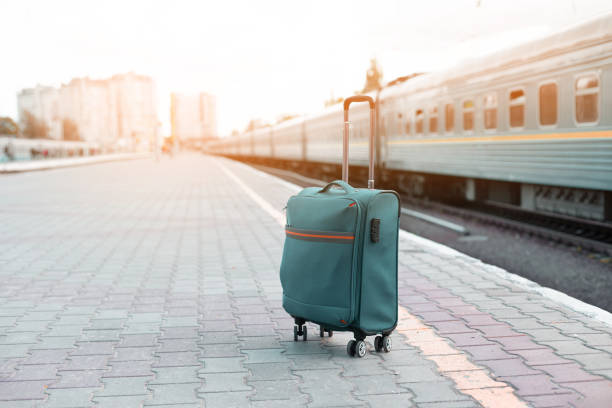 Blue summer travel luggage on the platform of the railway station