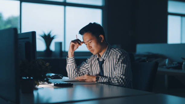 istock Businessman looking stressed during a late night in a modern office 1350582592
