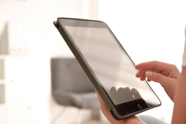 istock Woman working with modern tablet indoors, closeup 1350585984