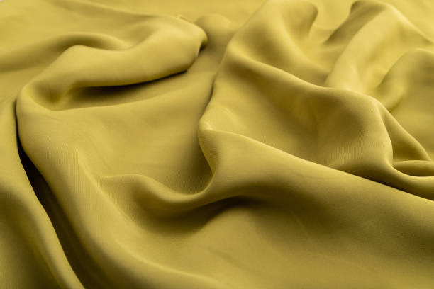 istock Fragment of green olive silk tissue. Side view, natural textile background and texture. wave concept, abstract. 1350587125