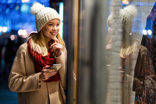istock Young woman walking through town using a mobile phone smiling with pleasure 1350592781