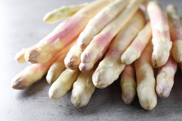 istock Pile of fresh white asparagus on grey table, closeup 1350592863