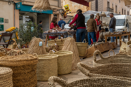 Santanyi, Spain; october 23 2021: Establishment selling traditional wicker baskets from the island of Mallorca, with custmoers in the background, out of focus