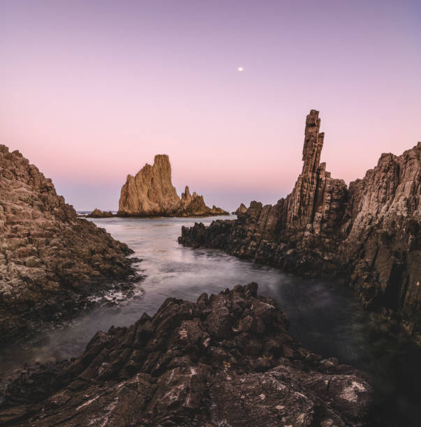 스페인 알메리아 카보 데 가타(cabo de gata)의 인어 산호초의 일몰에 있는 탁 트인 바다 경관으로 지중해 바다에서 수백만 년 된 고대 화산 용암 굴뚝을 볼 수 있습니다. - wave reef rock summer 뉴스 사진 이미지