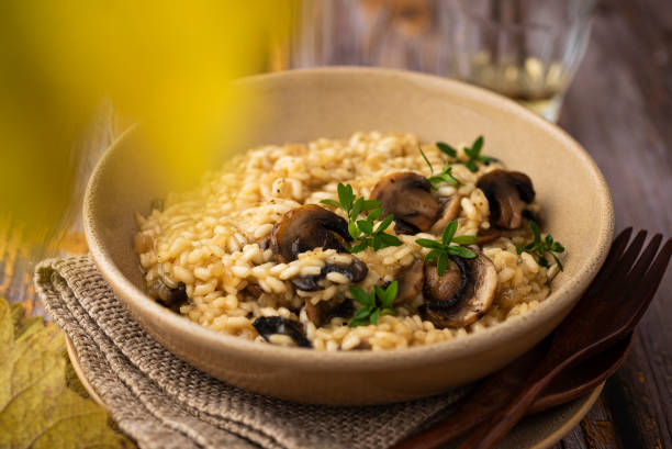 istock Mushroom risotto with thyme and a glass of wine 1350596080
