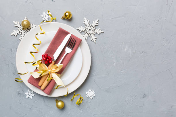 istock Christmas table place setting with christmas decor and plates, kine, fork and spoon. Christmas holiday background. Top view with copy space 1350597443