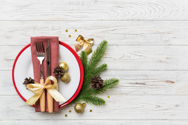 istock Christmas table place setting with christmas decor and plates, kine, fork and spoon. Christmas holiday background. Top view with copy space 1350597452
