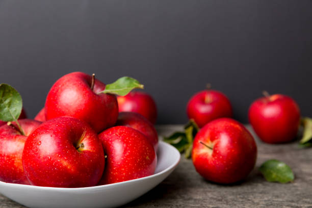 istock juicy red apples in a bowl or plate on the table top view. Copy space 1350597517