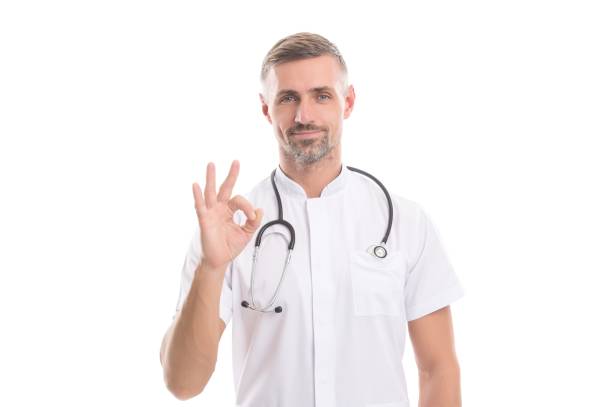 istock physician man with stethoscope medicine tool isolated on white do patient reception during coronavirus pandemic show ok gesture, perfect treatment 1350597530