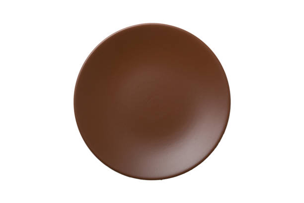istock Brown color ceramic round plate isolated over white background. Top view 1350597544