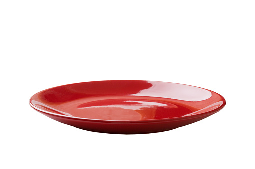 Red ceramic round plate isolated over white background. perspective view.