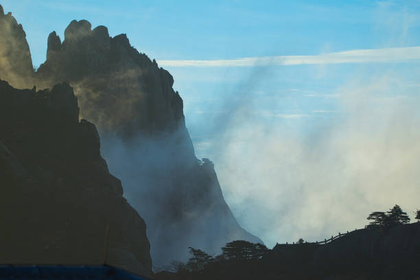 A dynamic view of white clouds surrounding a granite mountain. Landscape of Mount Huangshan (Yellow Mountain). UNESCO World Heritage Site. Anhui Province, China.