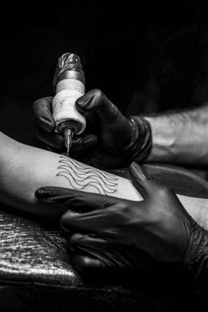 Tattoo art Unrecognizable Caucasian young woman getting a tattoo on her arm. forearm tattoos men stock pictures, royalty-free photos & images