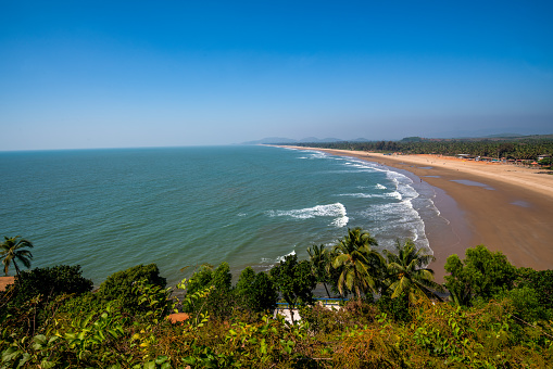 Idyllic view on  Main beach of Gokarna , South India(Karnataka ). Palm trees and sand and gentle waves roll over the beach sand. . relaxation in the winter months and spring - temperature around + 30 ° C and equal to water