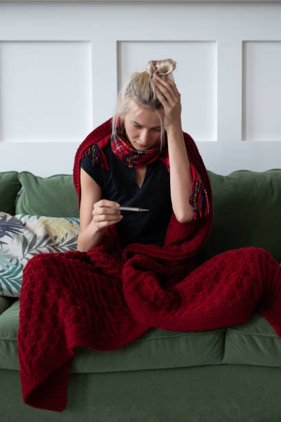 istock A young woman gets sick and takes her temperature 1350599041