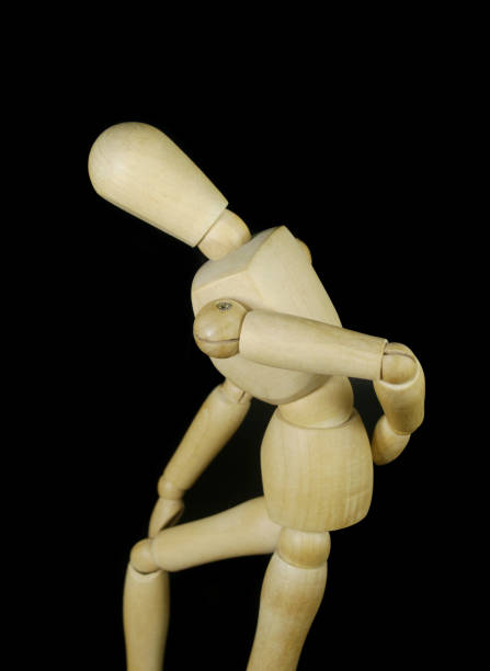 istock Figurine imitating backache and knee sickness isolated on black 1350602101