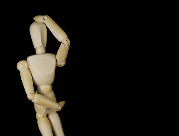 istock Wooden mannequin thinking about problem isolated on black background 1350602112
