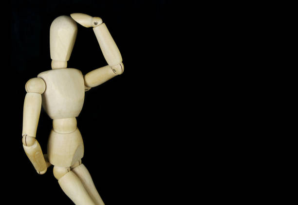 istock Wooden mannequin thinking about problem isolated on black background 1350602123