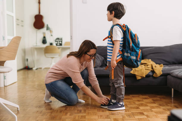 mother with child at home mother tie child shoelace. she preparing him for school first grade classroom stock pictures, royalty-free photos & images