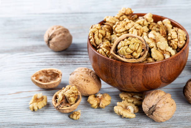 istock Purified walnuts in a brown wooden bowl 1350604808