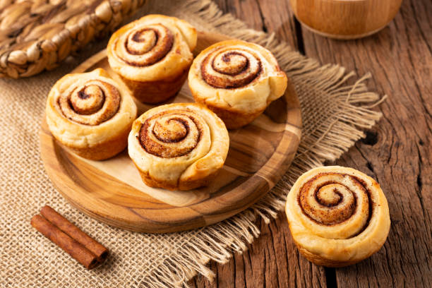 istock Cinnamon rolls on wooden background. 1350606235
