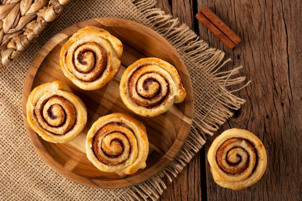 istock Cinnamon rolls on wooden background. 1350606250
