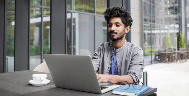 istock Businessman working on laptop computer in modern office 1350609333