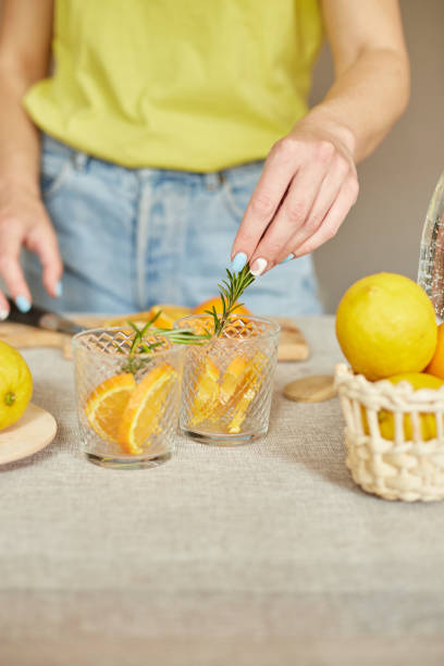 istock Female hand put rosemary in glasses, making fresh lemonade 1350609456