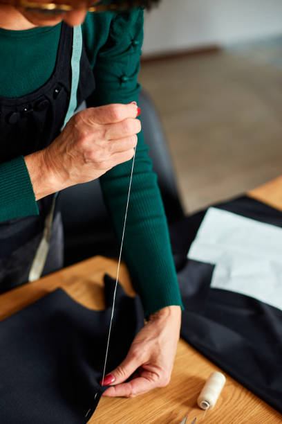 istock Step by step, 50-yers old woman sewing fabric with hand 1350609503