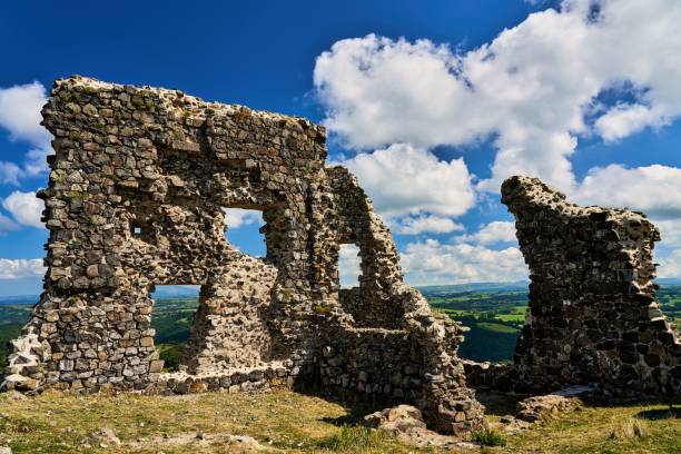 istock Castle ruins of Apchon against a blue sky with white clouds 1350612232