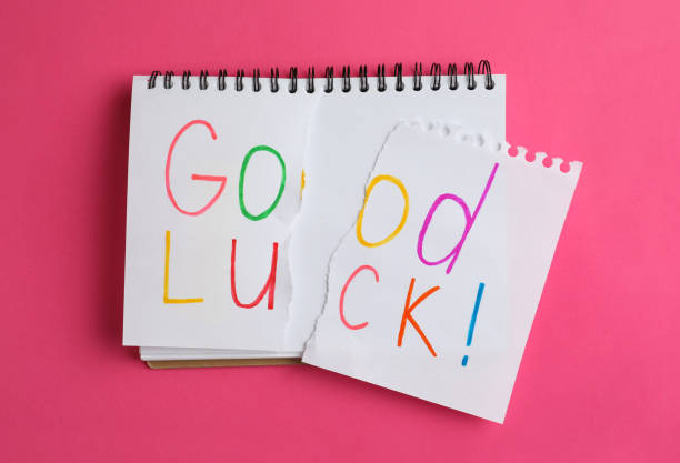 istock Torn phrase GOOD LUCK written in notebook on pink background, top view 1350613449