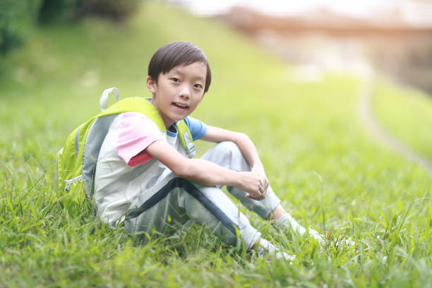 istock Little boy carrying a backpack walking back to school 1350613565