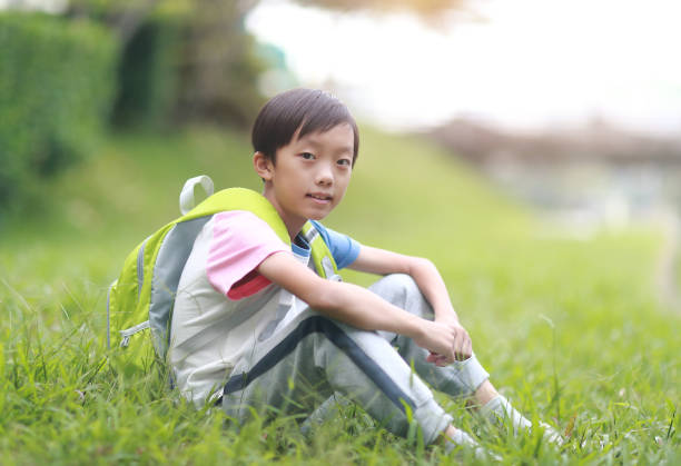istock Little boy carrying a backpack walking back to school 1350613581