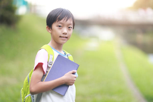 istock Little boy carrying a backpack walking back to school 1350613596