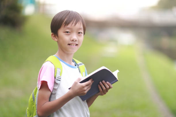 istock Little boy carrying a backpack walking back to school 1350613611