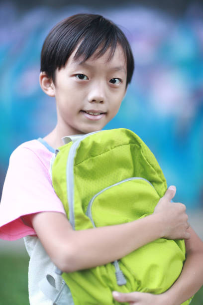 istock Little boy carrying a backpack walking back to school 1350613651