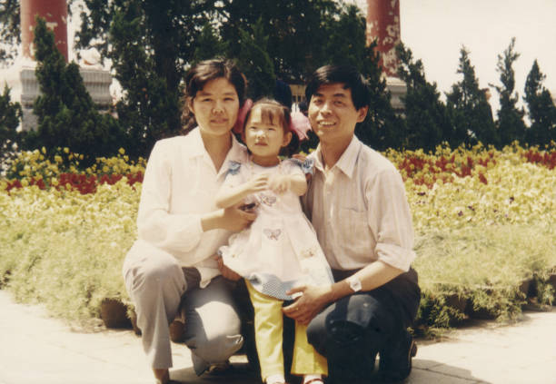 1980年代中国の両親と娘の実生活の古い写真 - 子供 写真 ストックフォトと画像