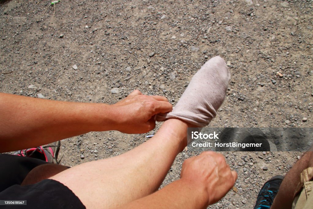 Putting a sock on one foot Body Part Stock Photo