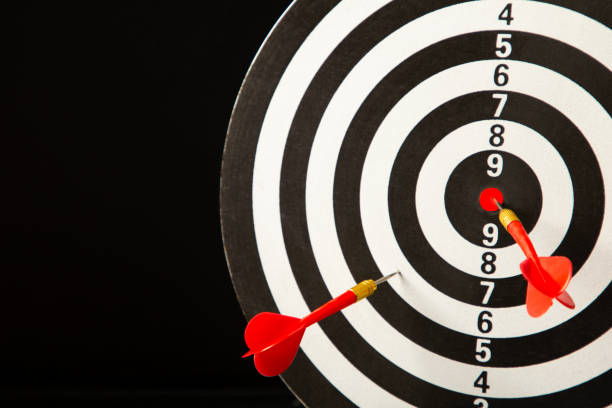 istock Dart board with red darts on black background. 1350618884