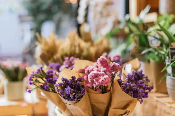 Close up of rose and purple bouquet in a flower shop.