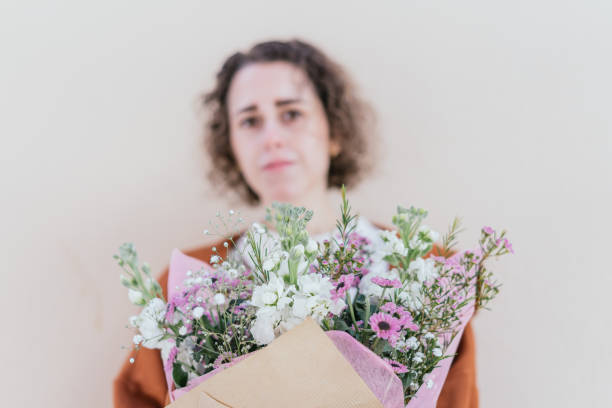 istock Young woman showing to the camera a bouquet. Selective focus. 1350619039