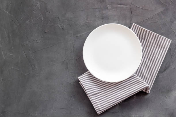 istock Top view of empty plate on napkin. Table setting for dinner 1350620289