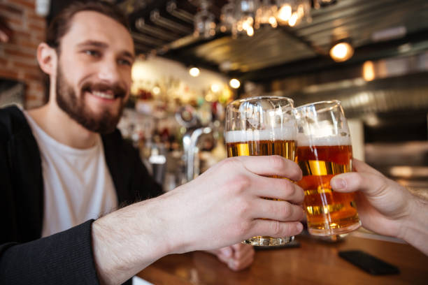 istock Cropped image of smiling man clinking glasses with friend 1350620657