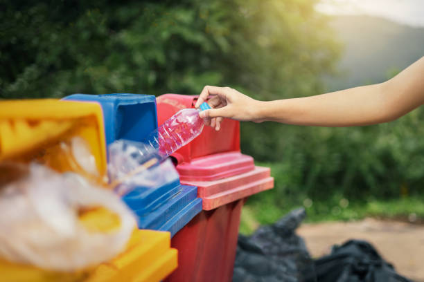istock hand holding bottle plastic garbage into trash in park 1350623486