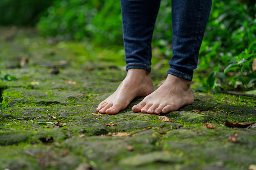 Bare feet of a woman stopped in the middle of the road enjoying the beauty of nature.