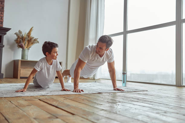 istock Happy boy doing push ups with father at home 1350626961